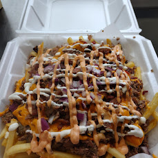 Loaded steak fries with cheese, onion and drizzled sauces